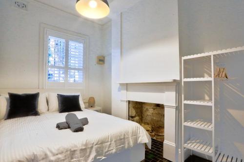 悉尼Good for Family 3 Bedroom House Darlinghurst with 2 E-Bikes Included的卧室配有白色的床和书架