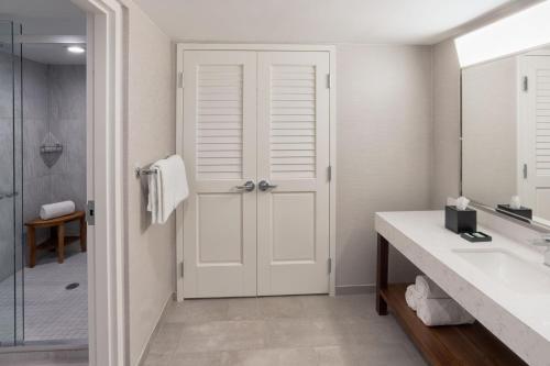 劳德代尔堡Courtyard by Marriott Fort Lauderdale East / Lauderdale-by-the-Sea的带淋浴的浴室和白色门