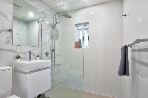 悉尼Ideal 3 Bedroom House in Chippendale with 2 E-Bikes Included的带淋浴和盥洗盆的白色浴室