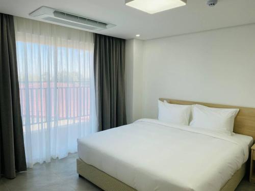 MabalacatThe Glory Hotel and Residence的卧室配有白色的床和窗户。
