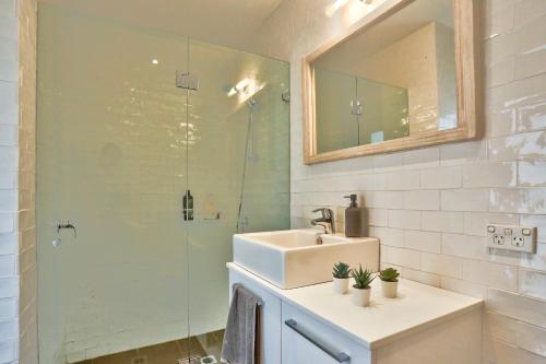 悉尼Spacious 3 Bedroom House Darlinghurst City Centre 2 E-Bikes Included的一间带水槽和玻璃淋浴的浴室