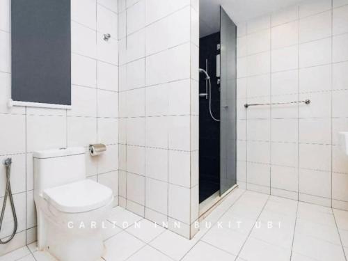 关丹OYO 89492 Carlton Inn Bukit Ubi的白色的浴室设有卫生间和淋浴。