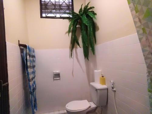 董里Goodnighthostel@Trang的一间带卫生间的浴室和墙上的植物