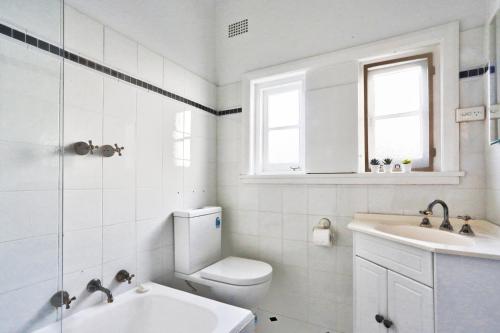 悉尼Spacious 3 Bedroom on the edge of Downtown Herford St 2 E-Bikes Included的白色的浴室设有卫生间和水槽。