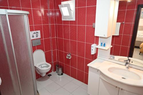 博德鲁姆梅利斯畔丝咏酒店的红色瓷砖浴室设有卫生间和水槽