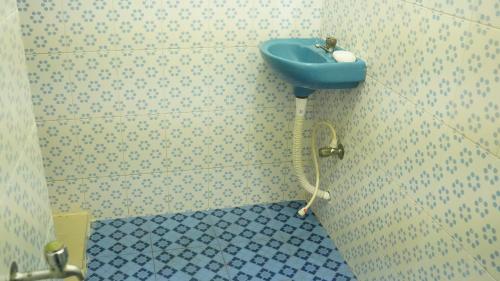 瓦尔卡拉SS Family Villa的墙上设有蓝色水槽的浴室