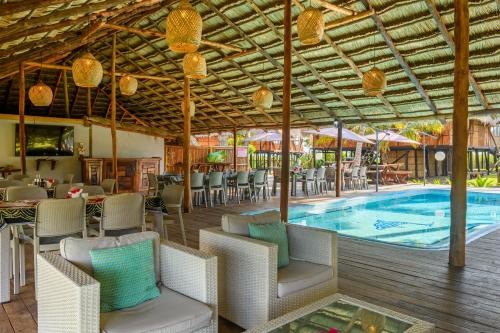 维兰库卢什Ocean Pearl Beach Lodge的一个带游泳池和桌椅的度假酒店