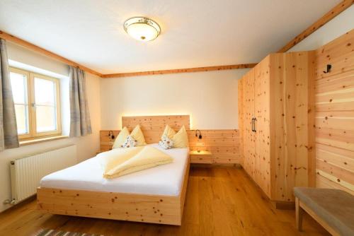 格罗萨尔比奥波霍夫奥北酒店的卧室配有一张床铺,位于带木墙的房间内
