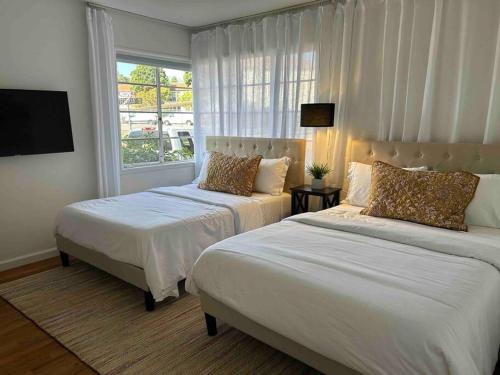 圣巴巴拉Darling, Peaceful, Near Beach, EV Charger的一间卧室设有两张床和窗户。