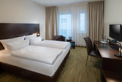 柏林斯比特尔马克西佳酒店的酒店客房设有一张大床和一张书桌。
