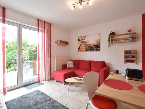 蒂门多夫Seaside Apartment in Insel Poel with Sauna的客厅配有红色的沙发和桌子