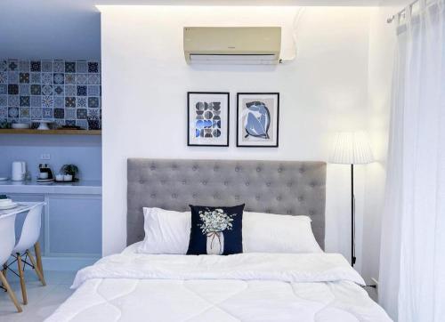 大雅台Moonlight House Tagaytay的卧室配有白色床和灰色床头板
