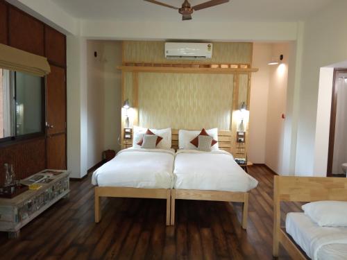 BegūrDiscovery Village Resorts的一间卧室配有两张带白色床单的床