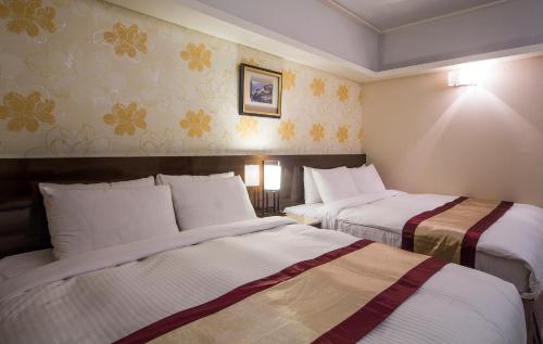 高雄美王精品飯店的一间酒店客房,内配两张床