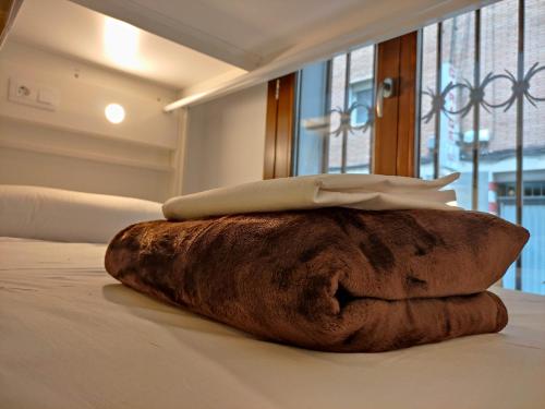格拉纳达Black Swan Hostel Granada的床上有毛巾