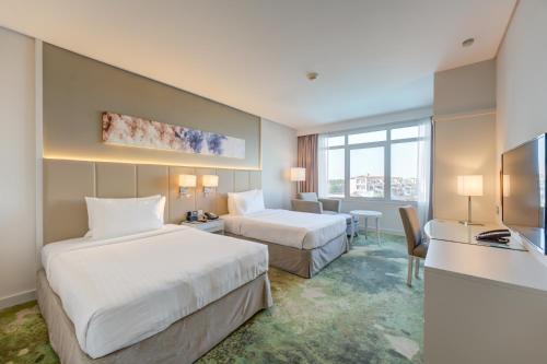 迪拜Copthorne Lakeview Hotel Dubai, Green Community的酒店客房配有两张床和一张书桌