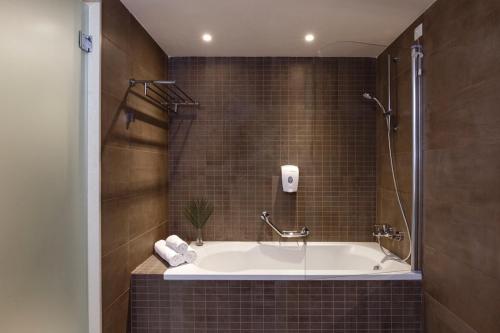 吉奥塔略罗德公主海滩酒店的设有带浴缸和淋浴的浴室。