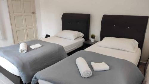 PendangD'LaMar Homestay的客房设有两张床和白色枕头。