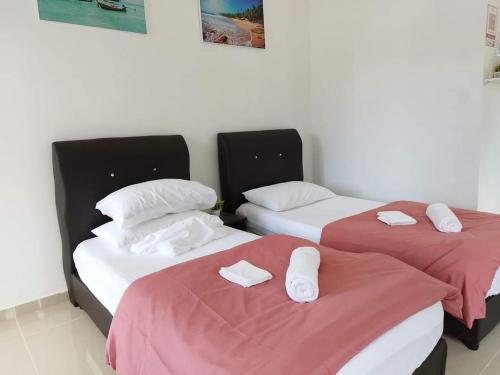PendangD'LaMar Homestay的配有红色和白色床单的客房内的两张单人床