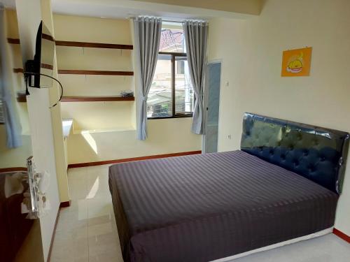 BlimbingBebek Kuning Residence的一间卧室设有一张床和一个窗口