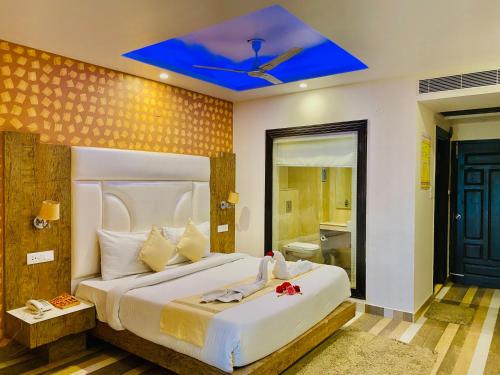 西姆拉Nature Mountain Valley View Resort -- A Four Star Luxury Resort的一间卧室设有一张蓝色天花板的大床