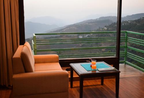西姆拉Nature Mountain Valley View Resort -- A Four Star Luxury Resort的美景客房 - 带椅子和桌子