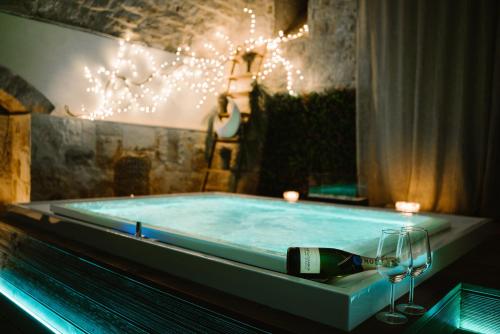 卡斯特拉纳格罗泰Apulia Suite的浴缸配有一瓶葡萄酒和玻璃