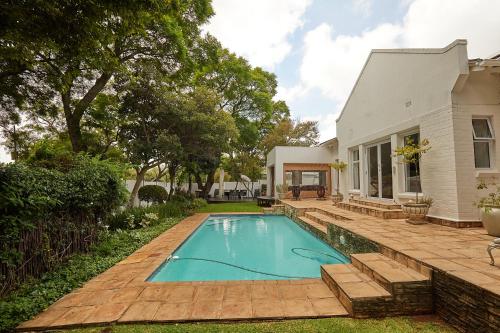 约翰内斯堡Maison Jacaranda的一座房子后院的游泳池