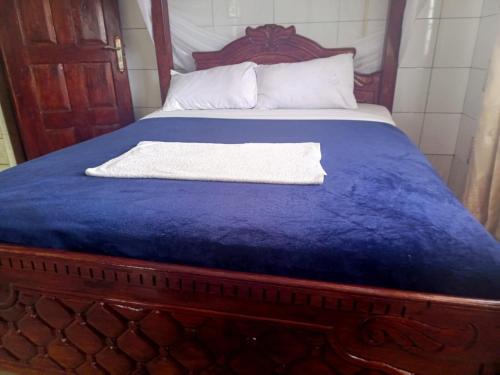 VoiOasis Hotel and Guest House. Voi的一张带蓝色毯子和白色毛巾的床