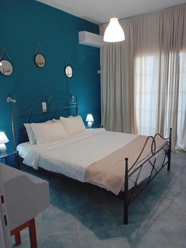 帕莱欧卡斯提撒spyridoula studio的一间卧室设有一张蓝色墙壁的大床