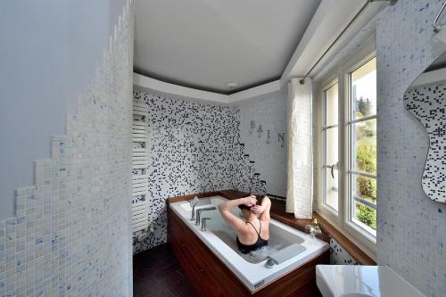 Vienne-en-Arthies维也纳阿提斯别墅住宿加早餐旅馆的妇女在浴室的浴缸里躺着