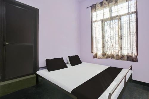 吉申格尔OYO Flagship Aravali Guest House & Restaurant的一间卧室设有两张床和窗户。