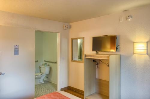 埃弗里特埃弗雷特北6号汽车旅馆的一间带卫生间的浴室和墙上的电视