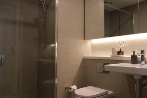 悉尼Sydney Olympic Park View Bliss Modern Design的带淋浴、卫生间和盥洗盆的浴室