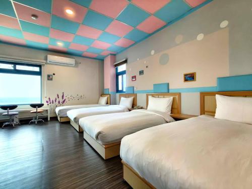 北竿蓝映海岸景观民宿 的一间设有三张床的客房,位于一个天花板的房间