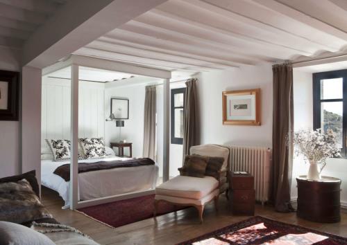 EnveitgLe château brangoly的一间卧室配有一张天蓬床和一把椅子