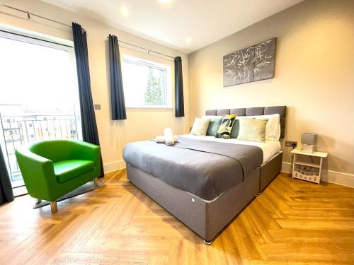 里克曼斯沃斯Refined Living with Free Wi-Fi and Parking的一间卧室配有一张床和一把绿色椅子