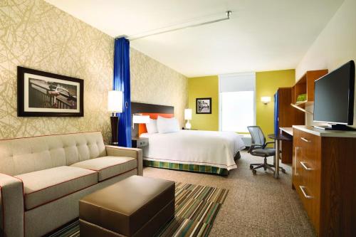 伯明翰伯明翰市中心希尔顿住宅2套房酒店的酒店客房,配有床和沙发