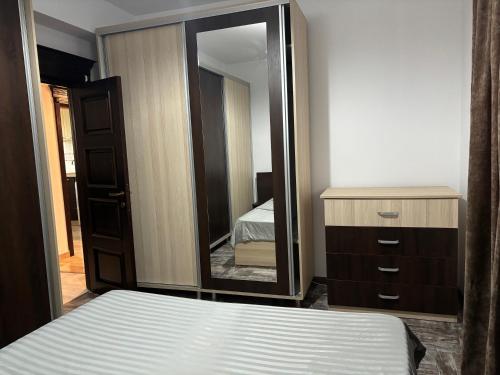 雅西Sweet Home Iasi Airport 2的一间卧室配有一张床和一面大镜子