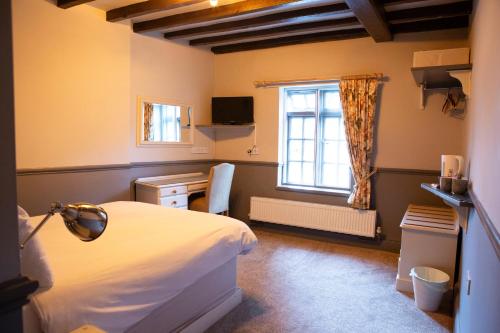 WhittingtonYe Old Boote Inn的卧室配有白色的床和窗户。