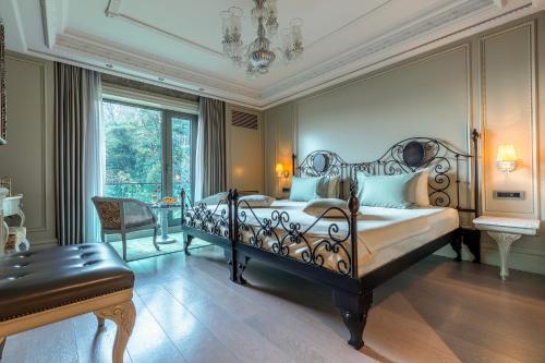 伊斯坦布尔MFB Tarabya Hotel的卧室配有1张床、1张桌子和1把椅子