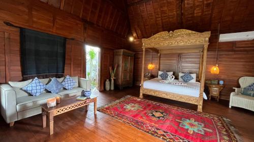坎古贾布纳米别墅酒店的一间卧室配有一张床、一张沙发和一张桌子