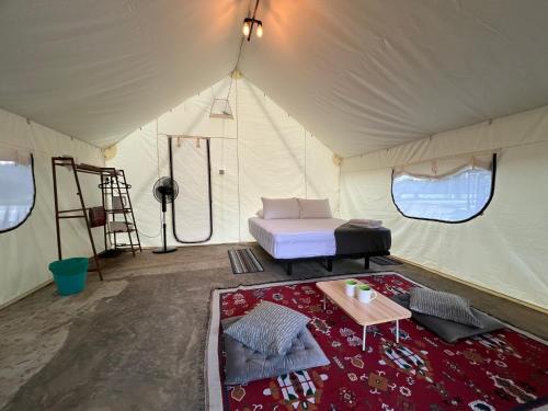 淡文Glamping at Xscape Tambun的帐篷配有一张床和一张桌子