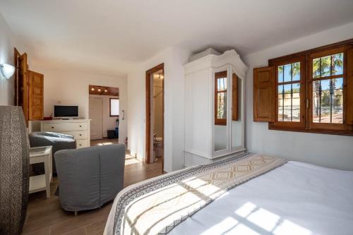 阿尔豪林格朗德Casa Amarilla Casitas的一间带一张床和一张书桌的卧室和一间厨房