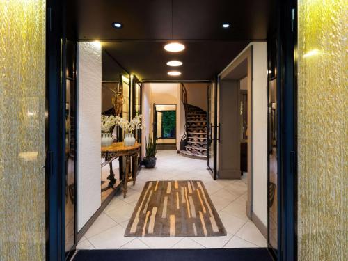 巴黎Hotel Stendhal Place Vendôme Paris - MGallery的走廊上设有1间带桌子和楼梯的用餐室