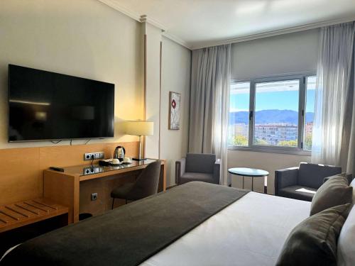 穆尔西亚Barceló Murcia Siete Coronas的配有一张床和一台平面电视的酒店客房