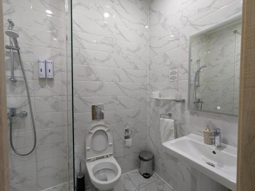 乌拉尔斯克Victoria Hotel的浴室配有卫生间、盥洗盆和淋浴。
