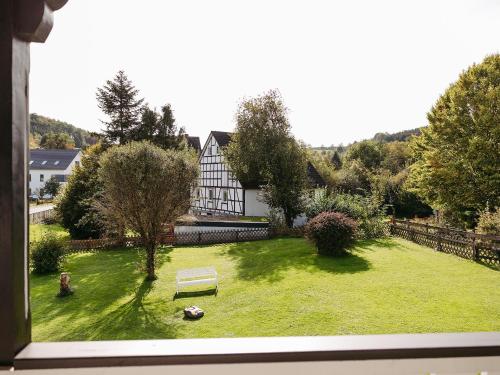 施马伦贝格Ferienwohnung Wennetal的从带房子的庭院的窗户欣赏美景