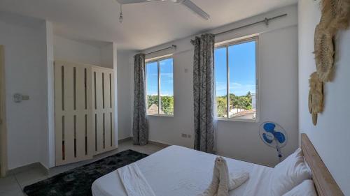 乌昆达Sea Spray Apartment的一间卧室设有一张床和两个窗户。