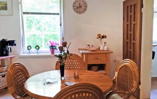 马洛1 Bedroom Lovely Home In Mahlow的一间带桌椅和时钟的用餐室